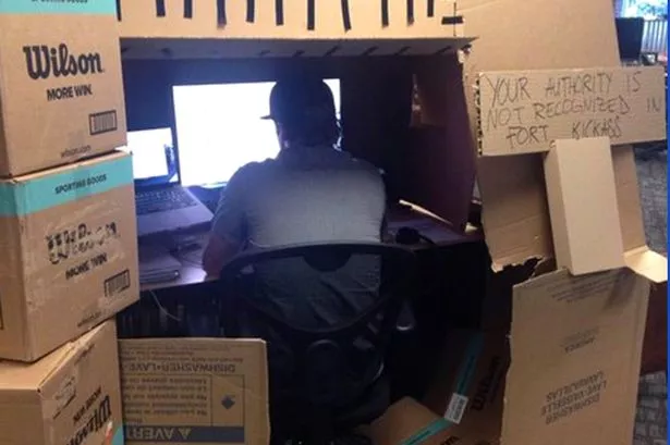Man-builds-fort-at-desk.jpg